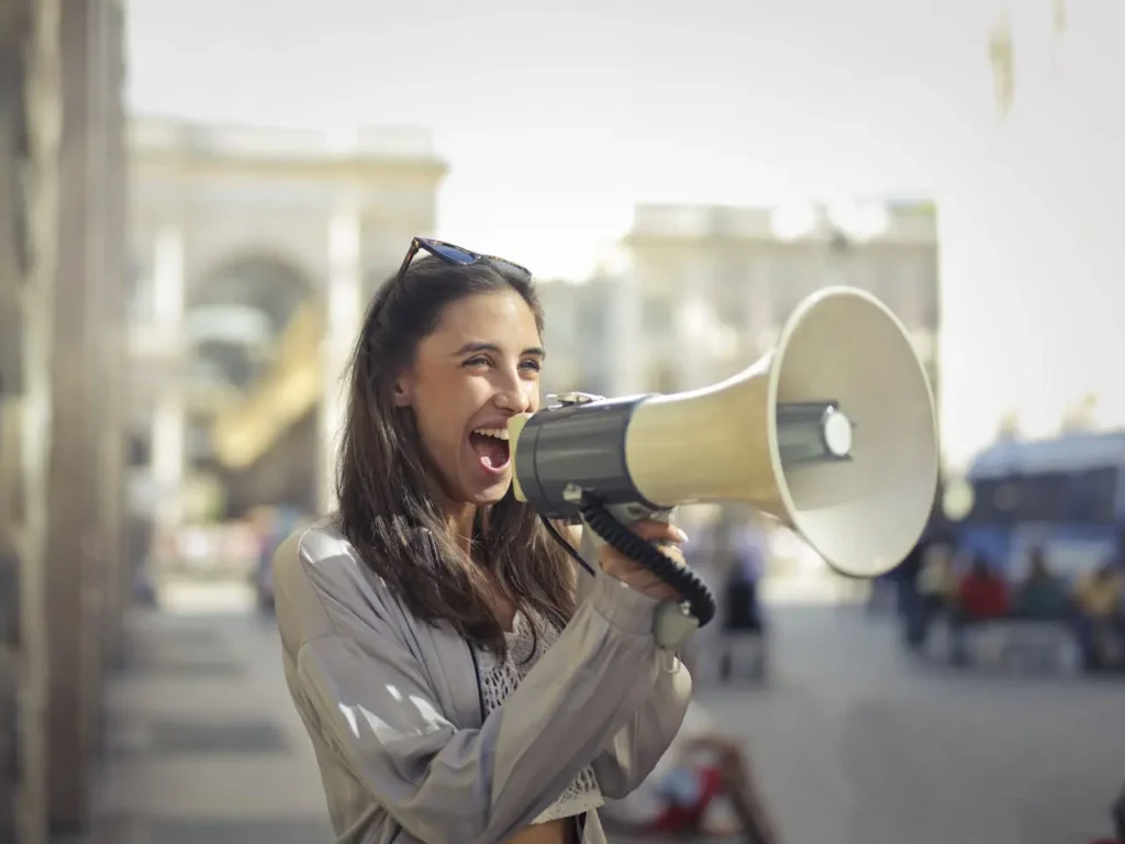 Second-wave feminism: Smiling woman shouting into a megaphone