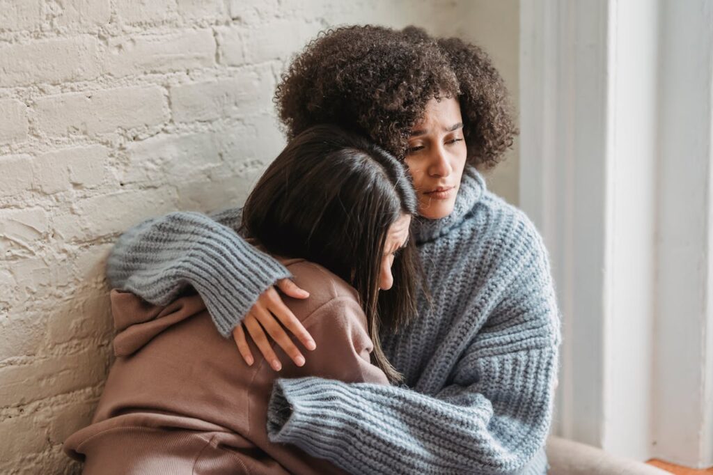 The Werther Effect: A woman tightly hugging a distressed girl