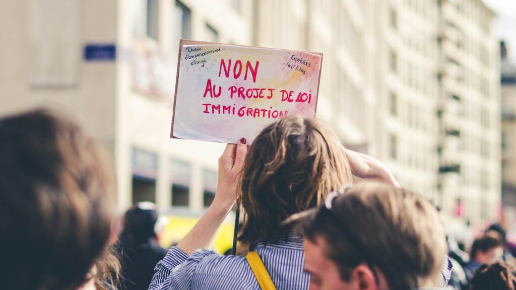 A protester holds up a sign that reads "No to the immigration bill" during a demonstration on a city street in Lyon.