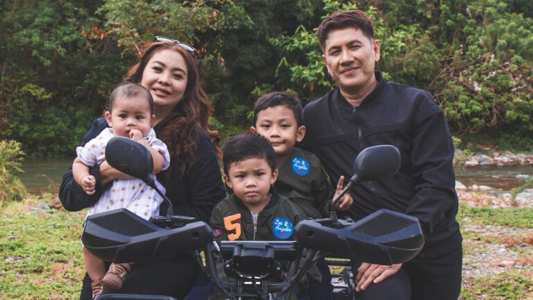 Misconceptions about Large Families: A family with three young children sitting and standing around and on a quad bike