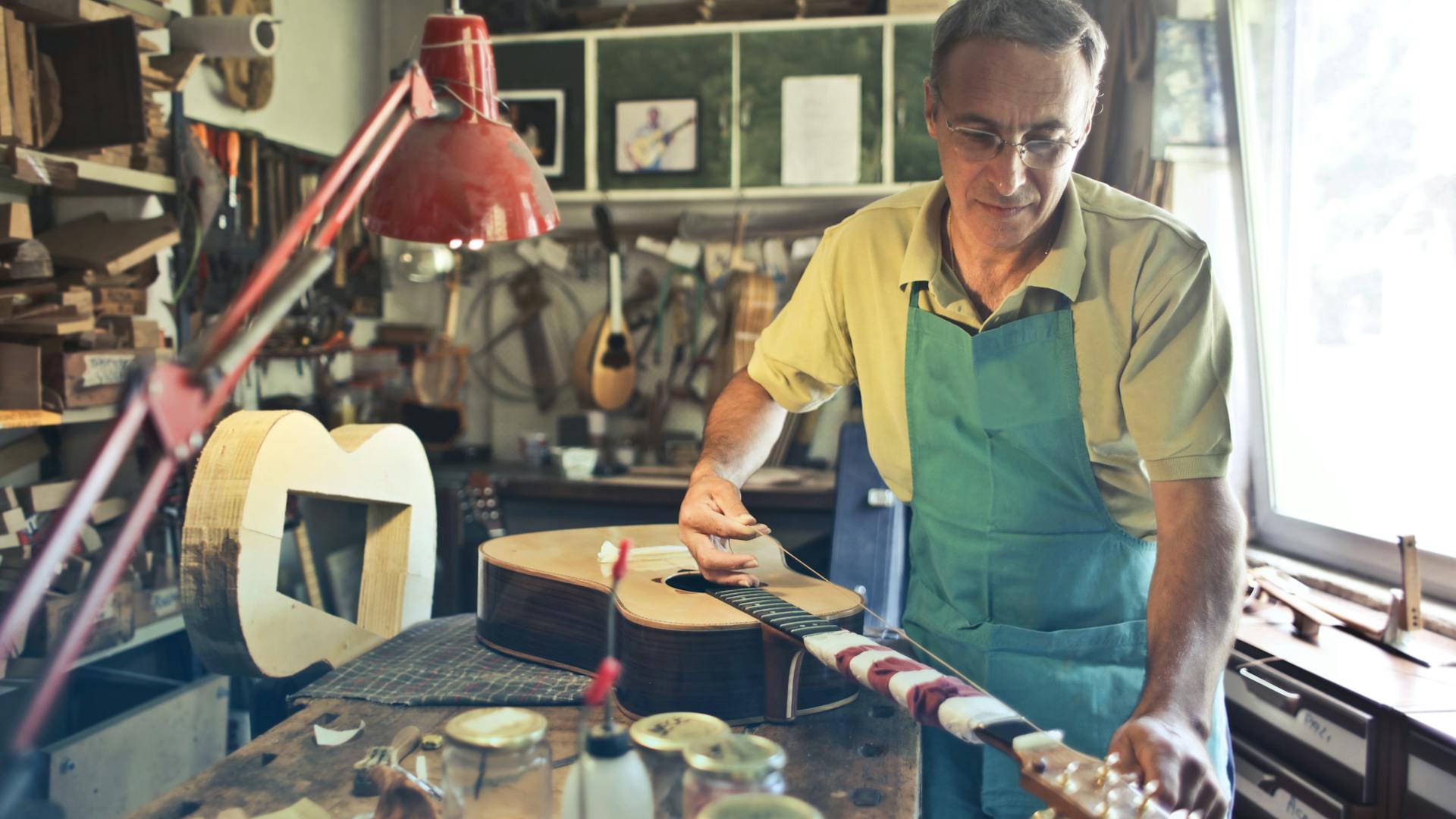 Modern craftsmanship: a craftsman in a workshop is making an acoustic guitar