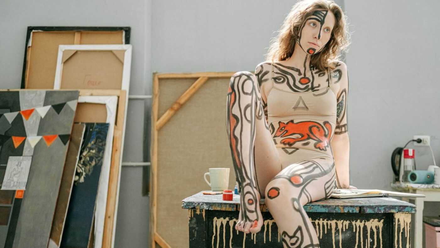 Art: Painted girl on a table in a studio