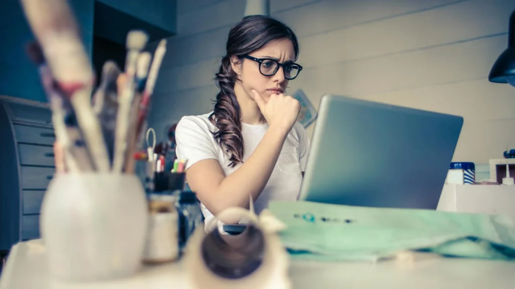 A pensive woman in front of a computer without access to information