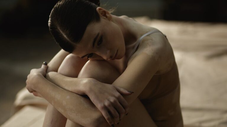 Send nudes culture: sad young woman curled up on a bed