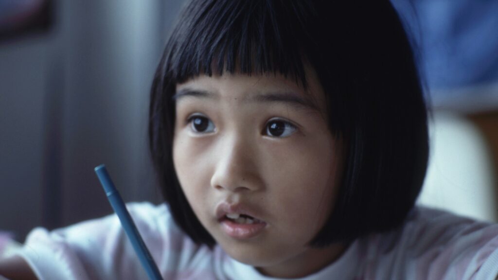 Burnout Kids: A close-up image of a young girl with wide eyes, holding a pencil, appearing focused and attentive.