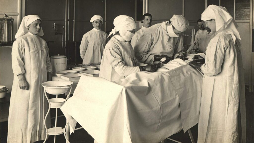 Medical Breakthroughs: A group of medical professionals in traditional surgical attire perform an operation in an early 20th-century operating room.