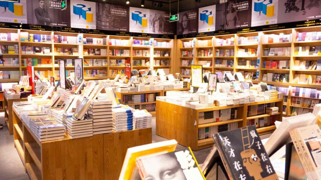 Modern Bestsellers: A brightly lit bookstore with books neatly arranged on shelves and tables, presenting a wide variety of literature from different genres.