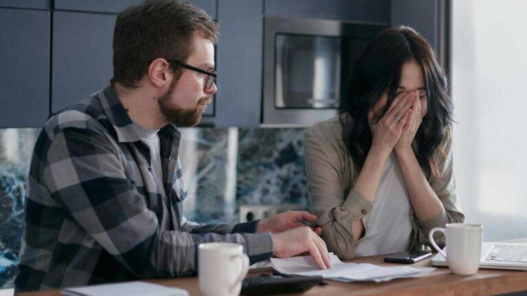 Controlling Behavior in Relationships: a woman holds her face in hands while listening to a man