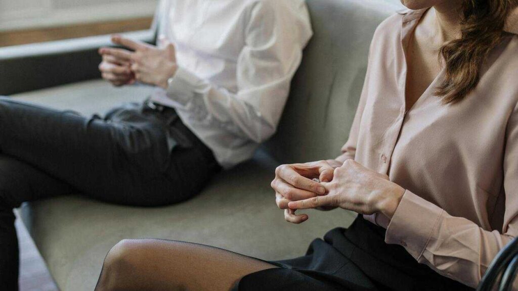Controlling Behavior in Relationships: a woman holds the ring on her finger, a man sitting beside her does the same