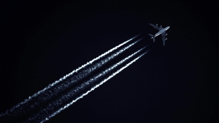 Aircraft Contrails
Photo by SevenStorm. Photo by JUHASZIMRUS/pexels.
The photo shows a high-flying aircraft against a dark sky, leaving four distinct contrails behind it.