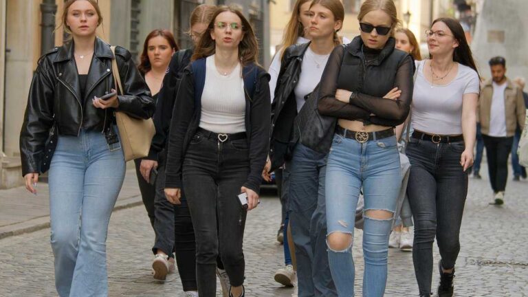 Gen Z language. Photo: Surprising_Media/pixabay. A group of young women in trendy, casual outfits walk together down a cobblestone city street.