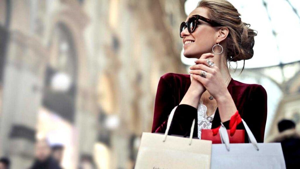 The Psychology of Wealth: Woman in sunglasses with shopping bags