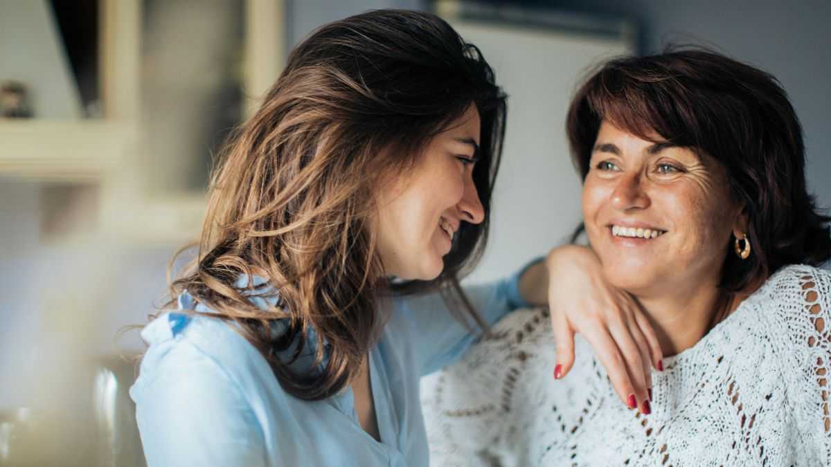 Human Aging Process: A young woman rests her hand on the shoulder of her older friend.
