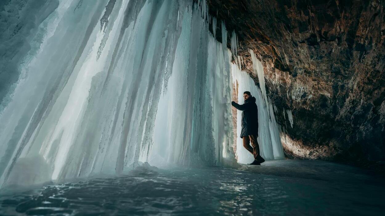 A researcher explores an ice cave where layers of permafrost have been trapped for thousands of years—similar places may conceal ancient microbes. Photo credit: Daniel Battersby/ Pexels
