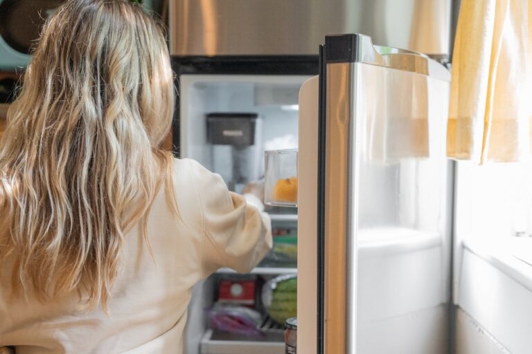 Why we overeat: A woman reaches into the refrigerator. Photo: Kevin Malik/ Pexels