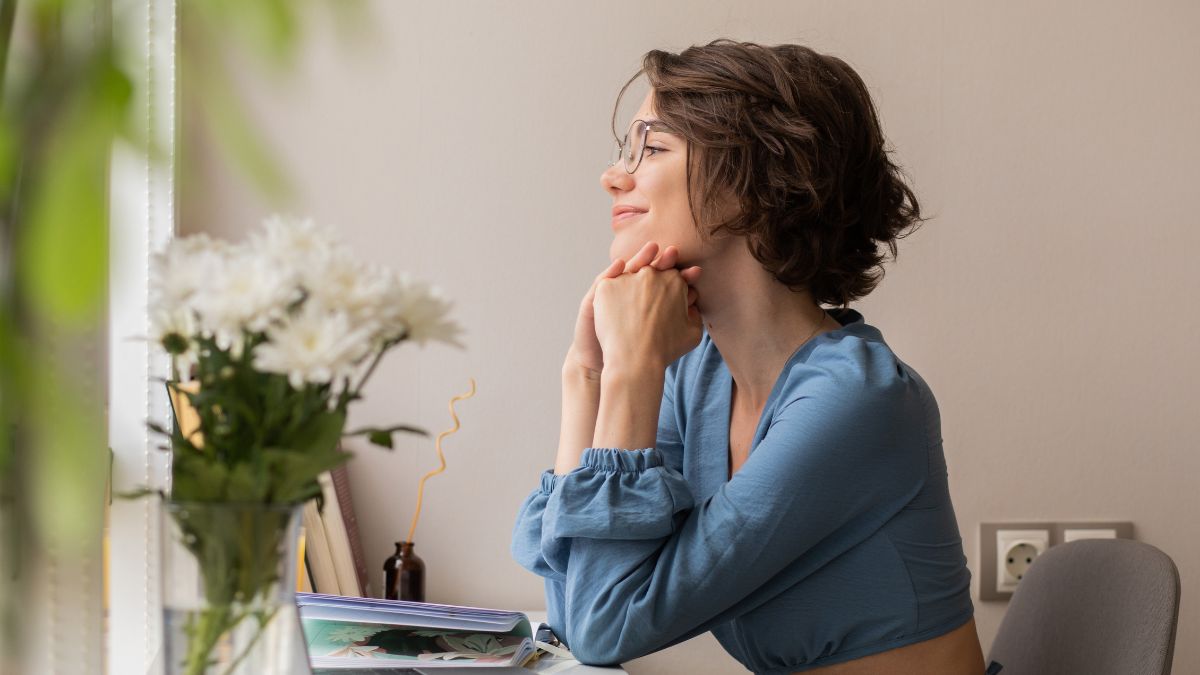 Dopamine effect on decisions: A smiling woman sits at a desk, looking out the window.