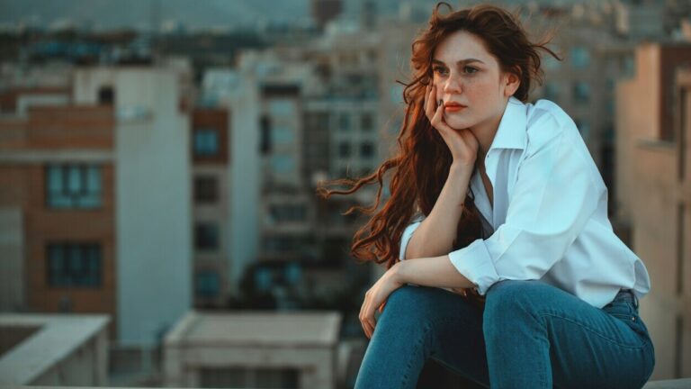 Young woman looking out over a city skyline – a symbol of the uncertainty surrounding the limit of human life and new longevity forecasts.