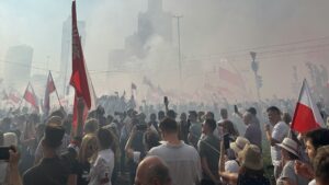Photo showing a person checking their phone (smartphone) in a dark room or at night, illustrating the impact of smartphone use on sleep and mental health. The image relates to Ipsos research on Poles' political sentiment, specifically their concerns about democracy in Poland and the future of the political system.