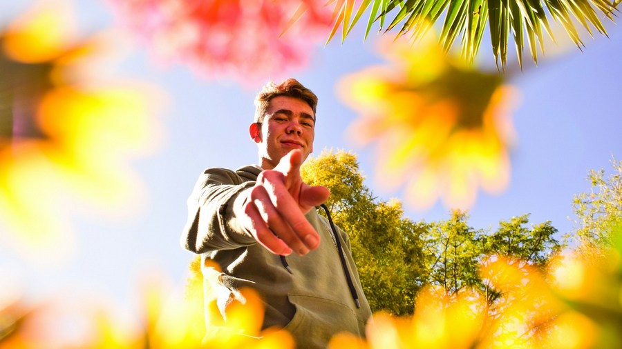 Humans and animals: A man points his finger toward the camera.