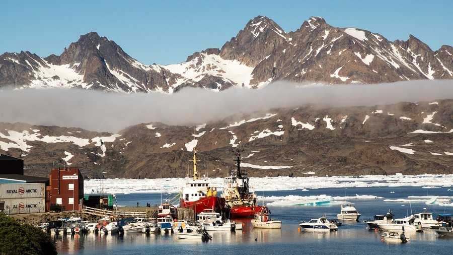 A solitary fishing vessel navigates the icy waters of the Arctic Sea, symbolizing the daily reality amidst the intensifying great power competition over Greenland's resources.