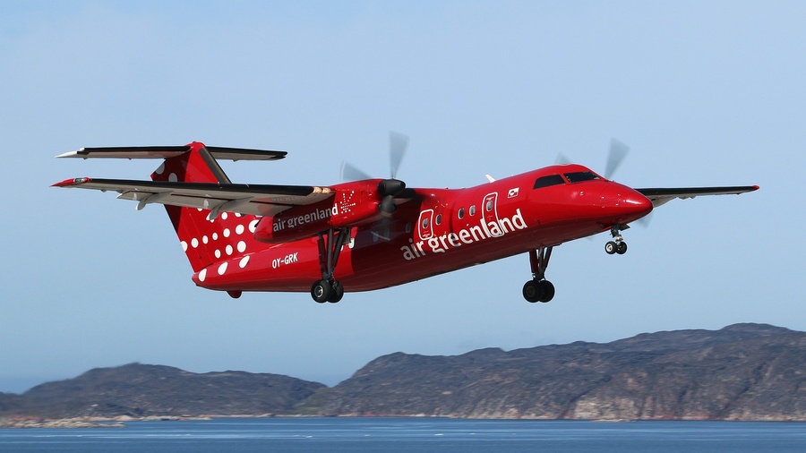 A red Air Greenland aircraft sits on a remote Arctic runway, serving as a symbol of the island's essential connectivity during the intensifying geopolitical power struggle over the region’s future.