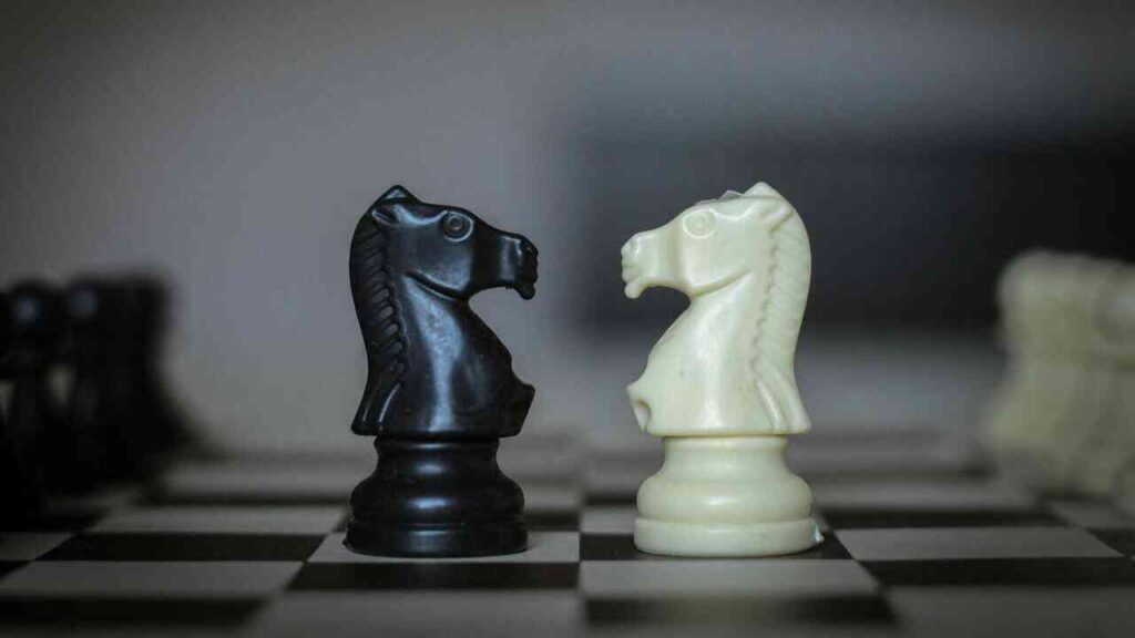 Two chess knights facing off serve as a powerful metaphor for rivalry. The image represents the balance between healthy vs toxic competition—contrasting a fair, rules-based struggle with a destructive drive to win at any cost.