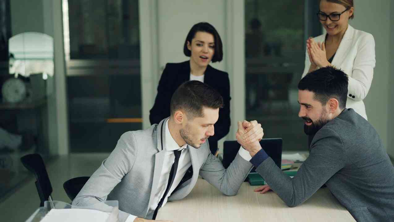 Competition in the professional world can spark growth or trigger conflict and intense pressure. This image captures the essence of healthy vs toxic competition at work, highlighting the thin line between ambition and destructive rivalry.