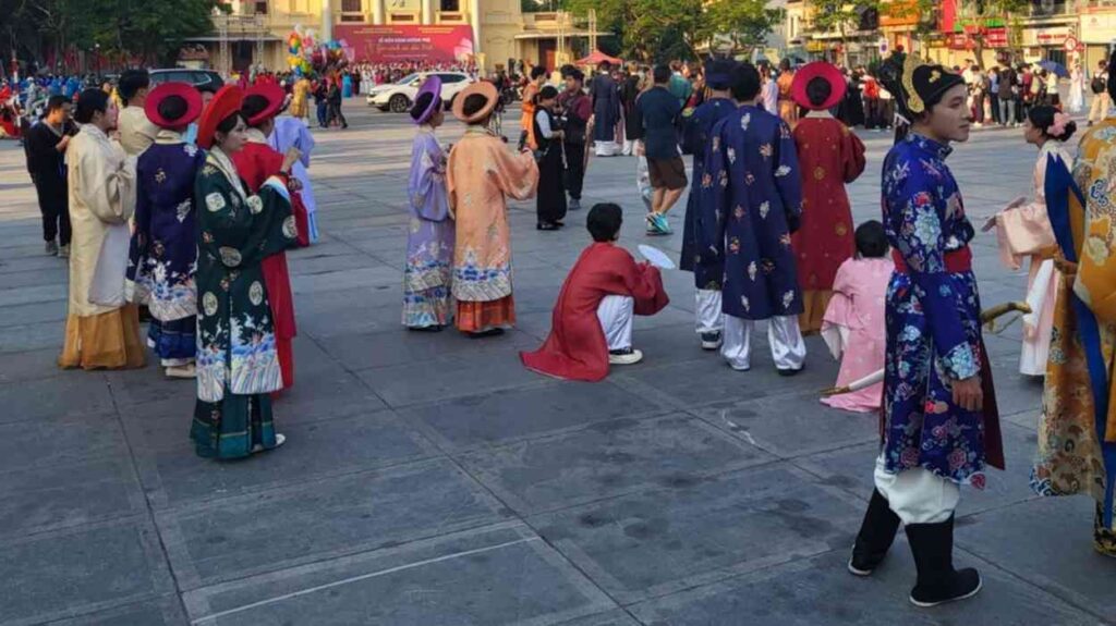 Vietnamese residents in traditional clothing on a city square — an image of Asia’s economic paradox.