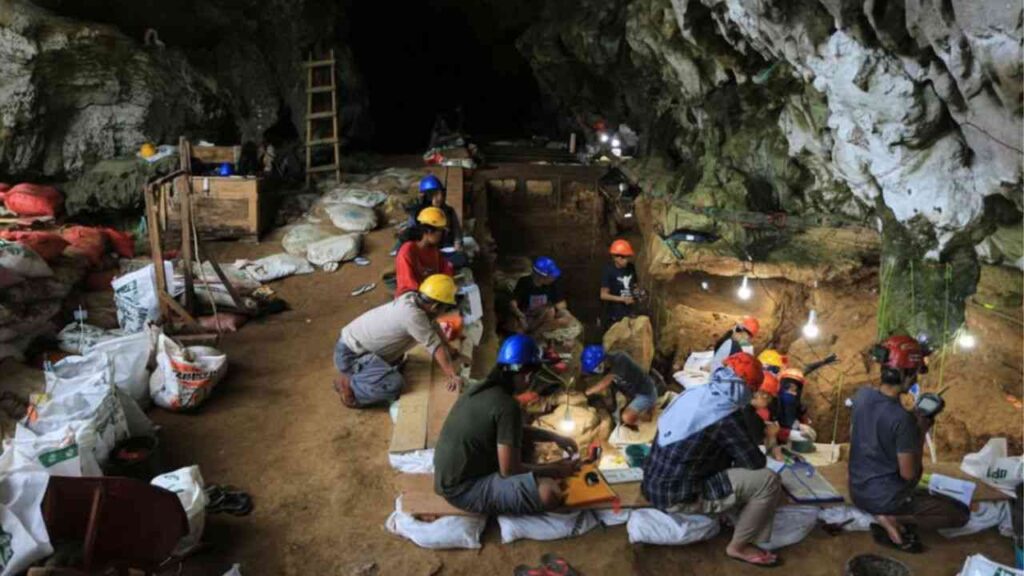 The interior of a cave, with people working inside.
