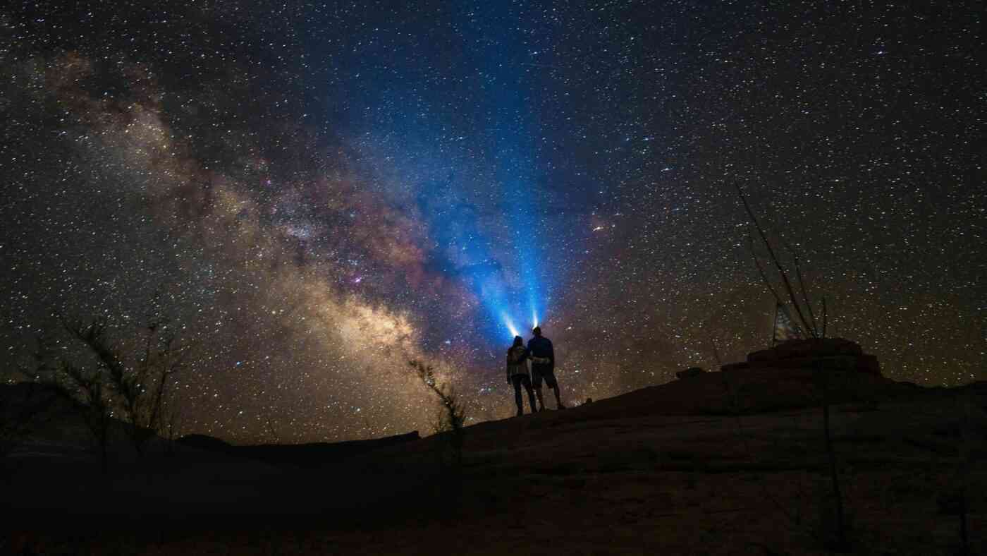 People with flashlights looking up at the stars.