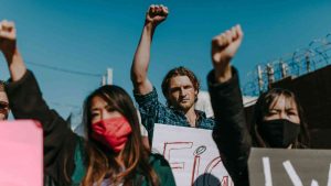 Young people protest with raised fists during a street demonstration