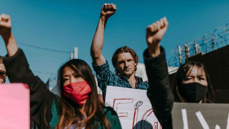 Young people protest with raised fists during a street demonstration