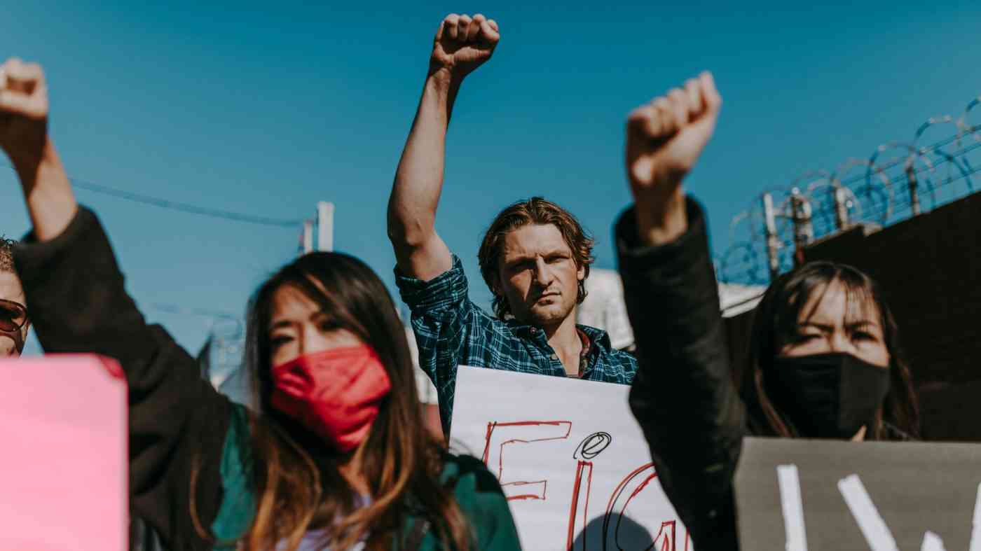 Young people protest with raised fists during a street demonstration