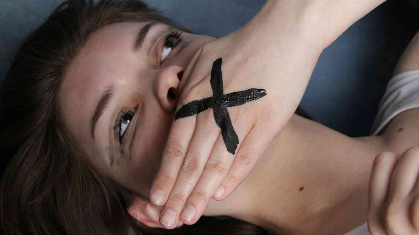 A woman covering her mouth.