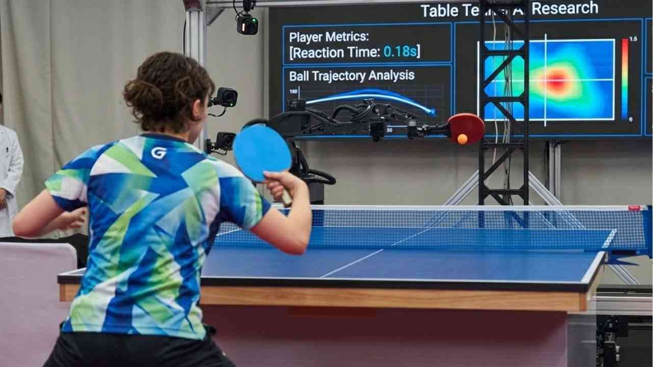 The photo shows a woman playing table tennis with a robot. It depicts a robot-versus-human contest.