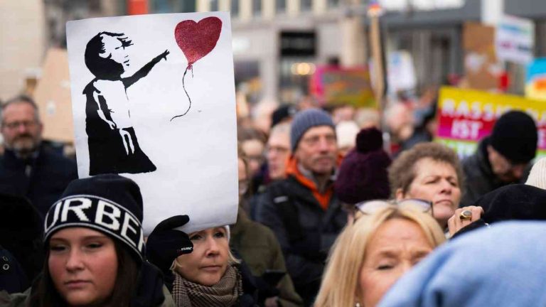 Protesters holding a poster of a child with a heart symbolise a call for compassion in politics.