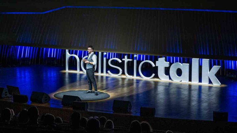 A speaker taking the stage at the Holistic Talk festival of ideas