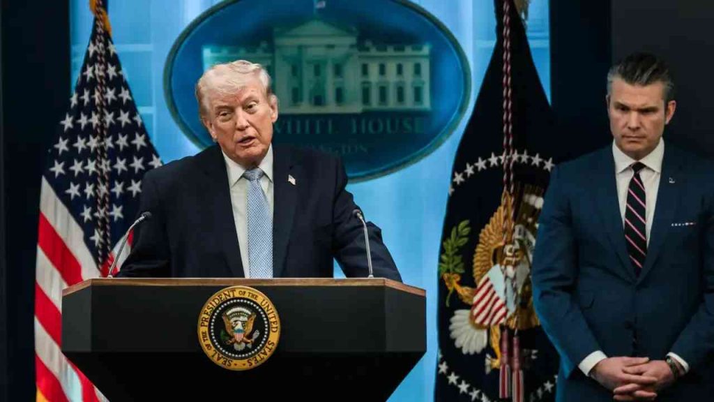 Donald Trump speaks at the White House during a press conference, with a member of the U.S. administration standing beside him. The image illustrates the subject of Trump’s second term, the war with Iran, and the decisions of the American president.