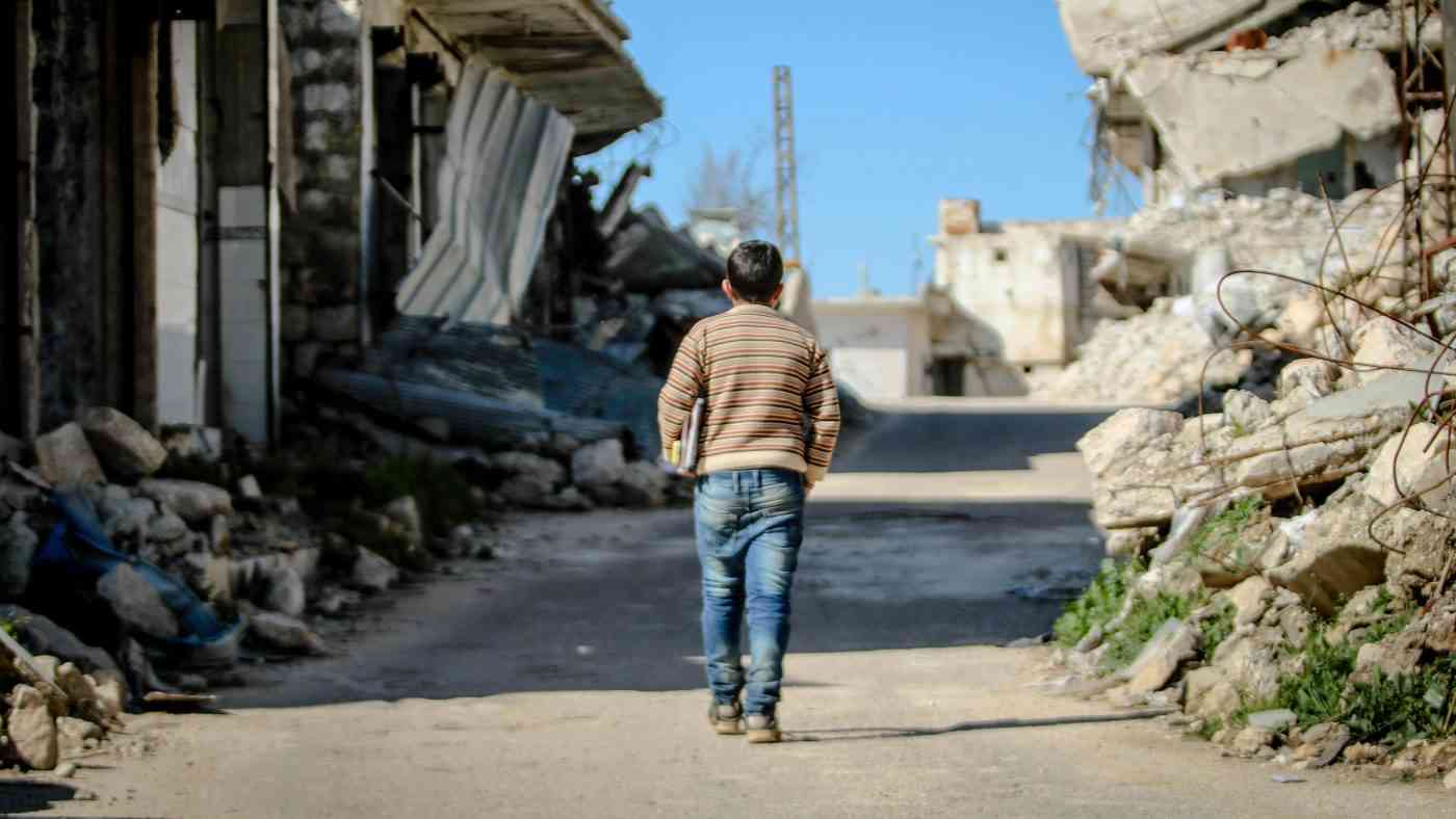 A child walking through ruins, illustrating the trauma of children at war.