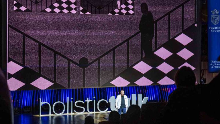A view of the stage and a speaker during the Holistic Talk ideas conference.