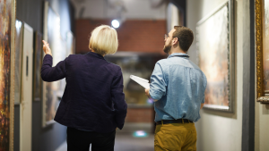 A woman and a man looking at paintings in a museum — the global art market and the culture of soft power.