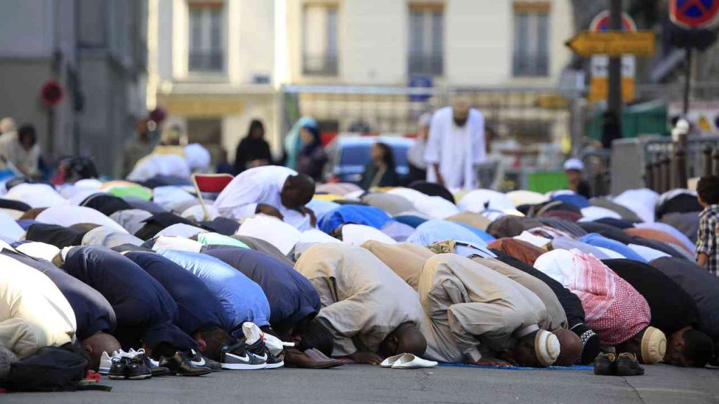 Muslims praying in the street in a European city during a communal prayer.