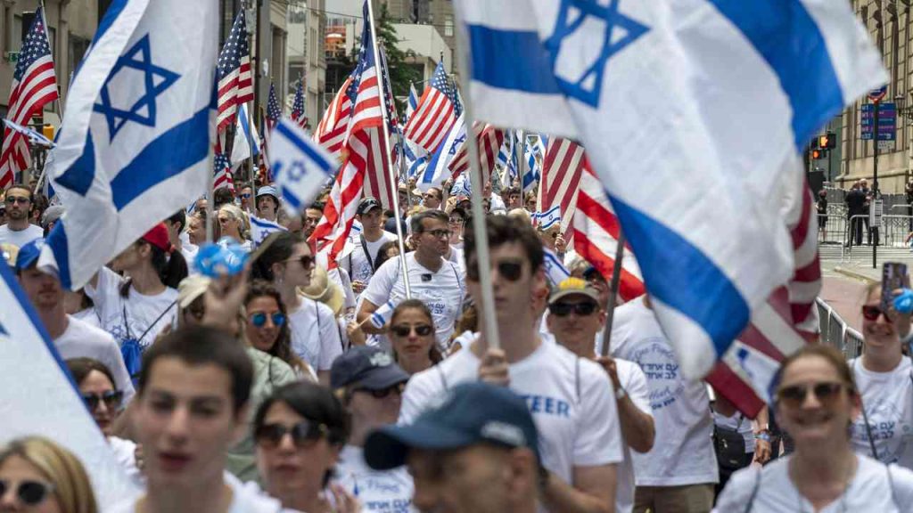 Participants in a march in New York carrying Israeli and United States flags.