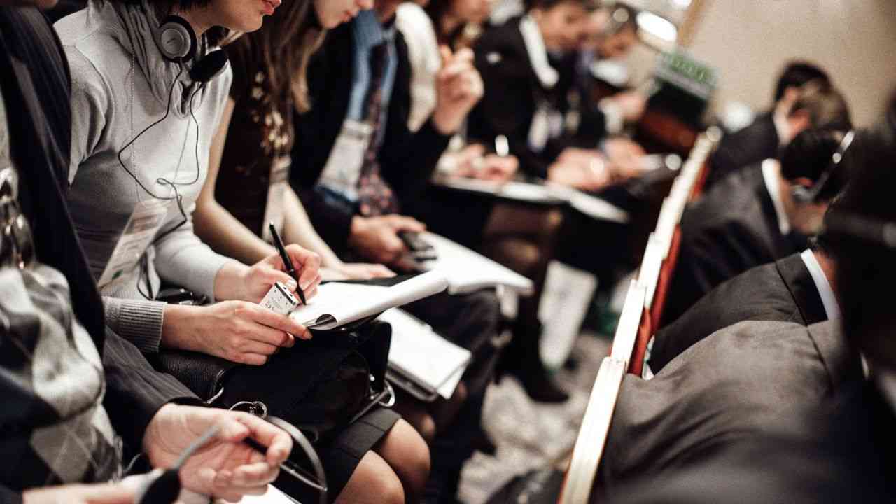 People sit in a row and write about what the media’s image of disasters shows.