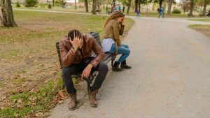 A couple sits side by side, but silence in the relationship divides them emotionally.