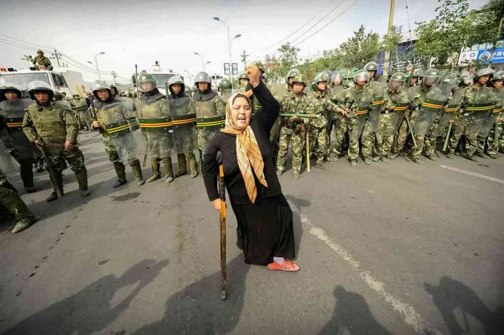 PHOTO: AFP/EAST NEWS TO GO WITH STORY China-unrest-Xinjiang-attacks BY PASCALE TROUILLAUDIn this picture taken on July 7, 2009, An ethnic Uigur woman on crutches protests in front of a line of paramilitary police in Urumqi, in China's farwest Xinjiang region. China has pointed the finger at Uighur separatists and terrorists for the recent deadly unrest in its Muslim-populated far northwest, but experts question how real those threats are.  AFP PHOTO/Peter PARKS