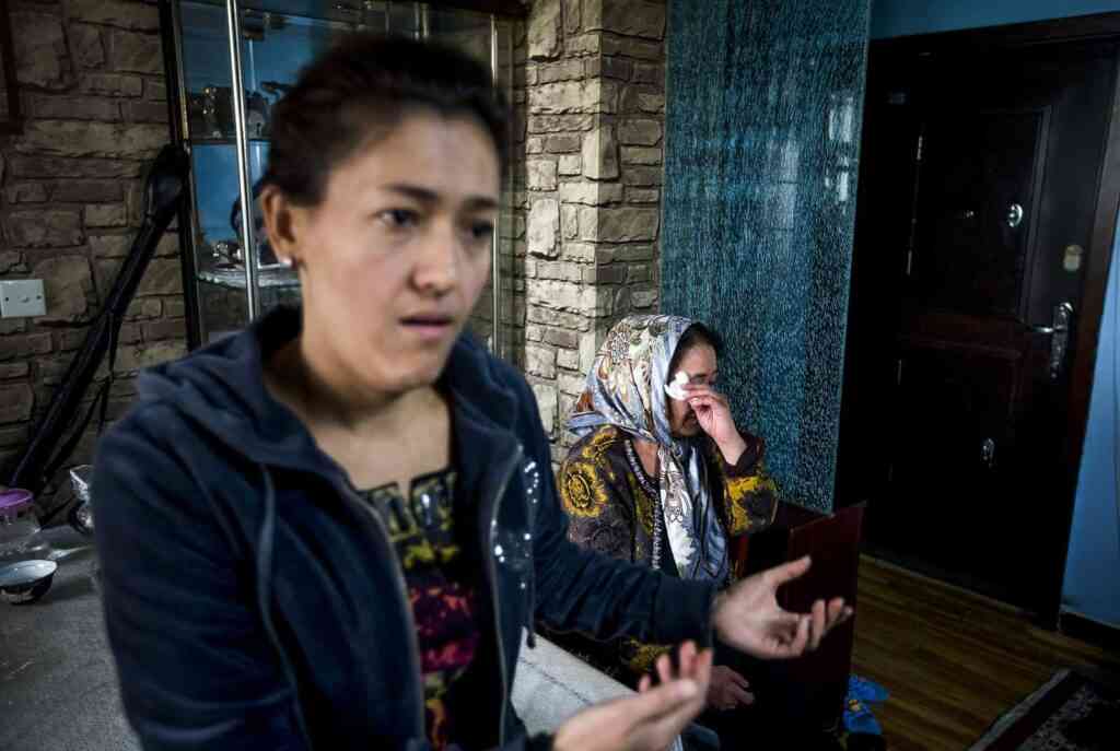 Guzaili Nu'er, wife of Ilham Tohti, left, speaks as Nasipuhan, mother of Tohti, cries during an interview at her house in Beijing Thursday, Jan. 16, 2014. Police have taken away Ilham Tohti, an outspoken scholar of China's Turkic Uighur ethnic minority and raided his home, seizing computers, cellphones and even his students' theses, his wife said Thursday. (AP Photo/Andy Wong), APTOPIX