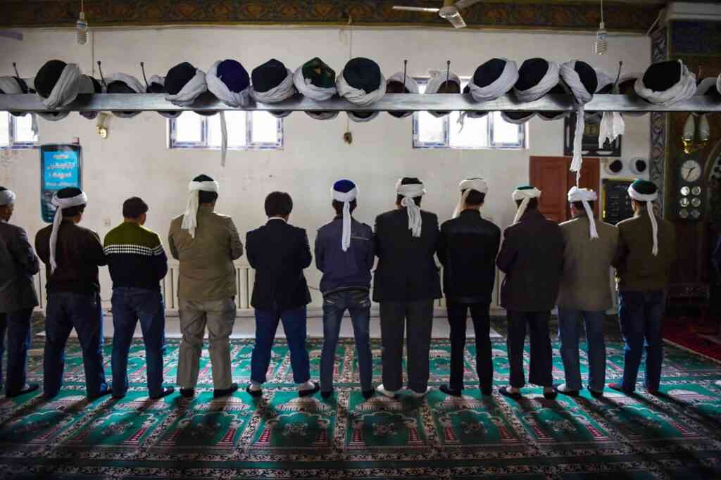 TOPSHOT - This photo taken on April 16, 2015 shows Uighur men praying in a mosque in Hotan, in China's western Xinjiang region. - The prefecture in the region's south has seen an explosion in the construction of 