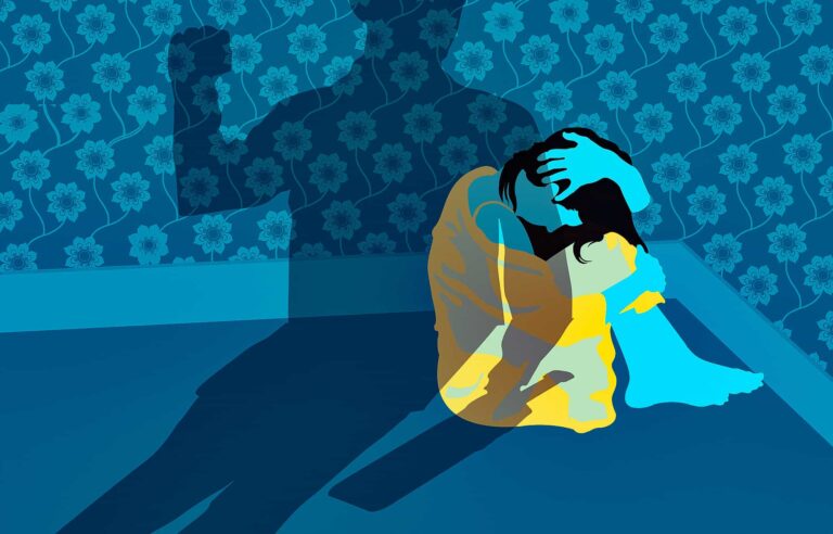 Woman cowering in corner under shadow making a fist