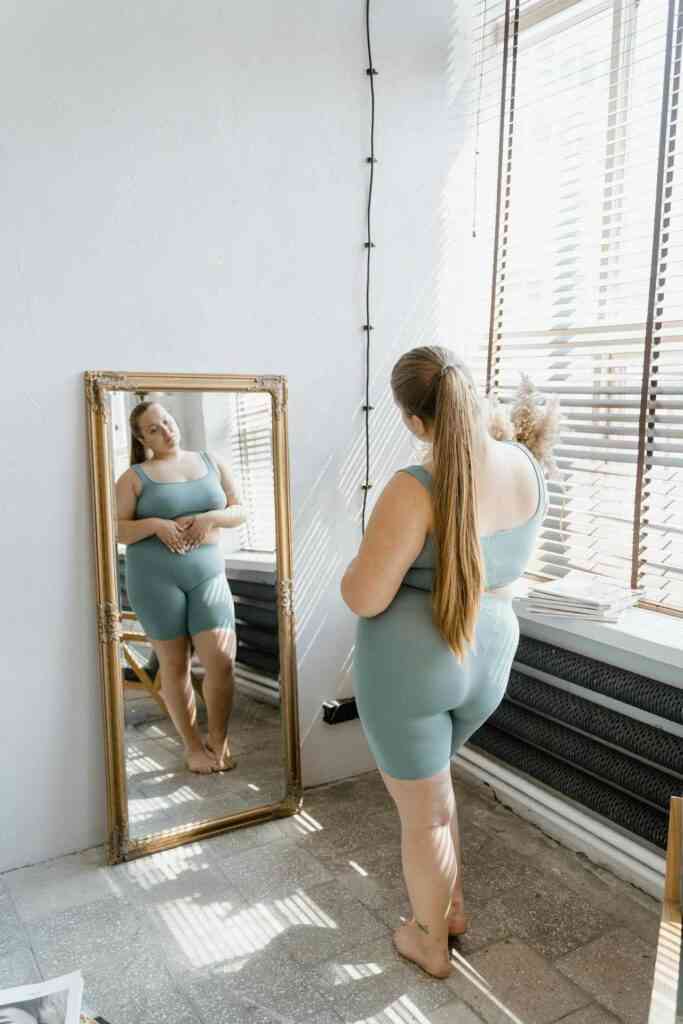 otyła kobieta spogląda w lustro